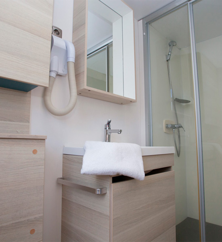 Seconde salle de bain avec cabine de douche, rangements modernes et sèche-cheveux