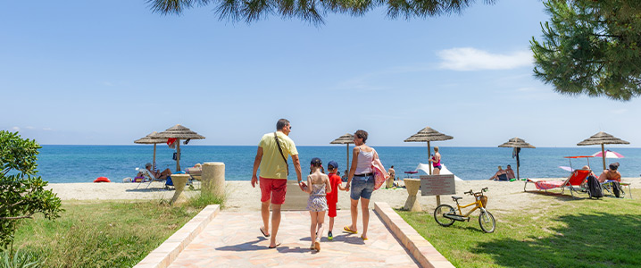 Famille marchant sur le sentier direct du camping vers la plage